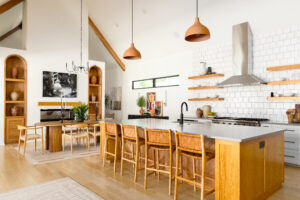 A bright and open kitchen and dining space with natural wood finishes fills the space of this Hyde Park home in Corpus Christi.