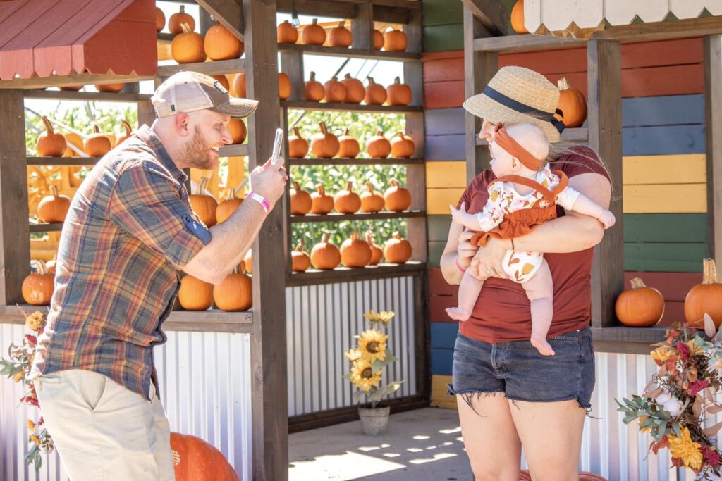 a family poses for a photos near pumpkins at Rockin K Farms.