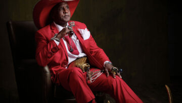 Ronnie “Pointy Boots” Mathis poses for a portrait in a red suit.