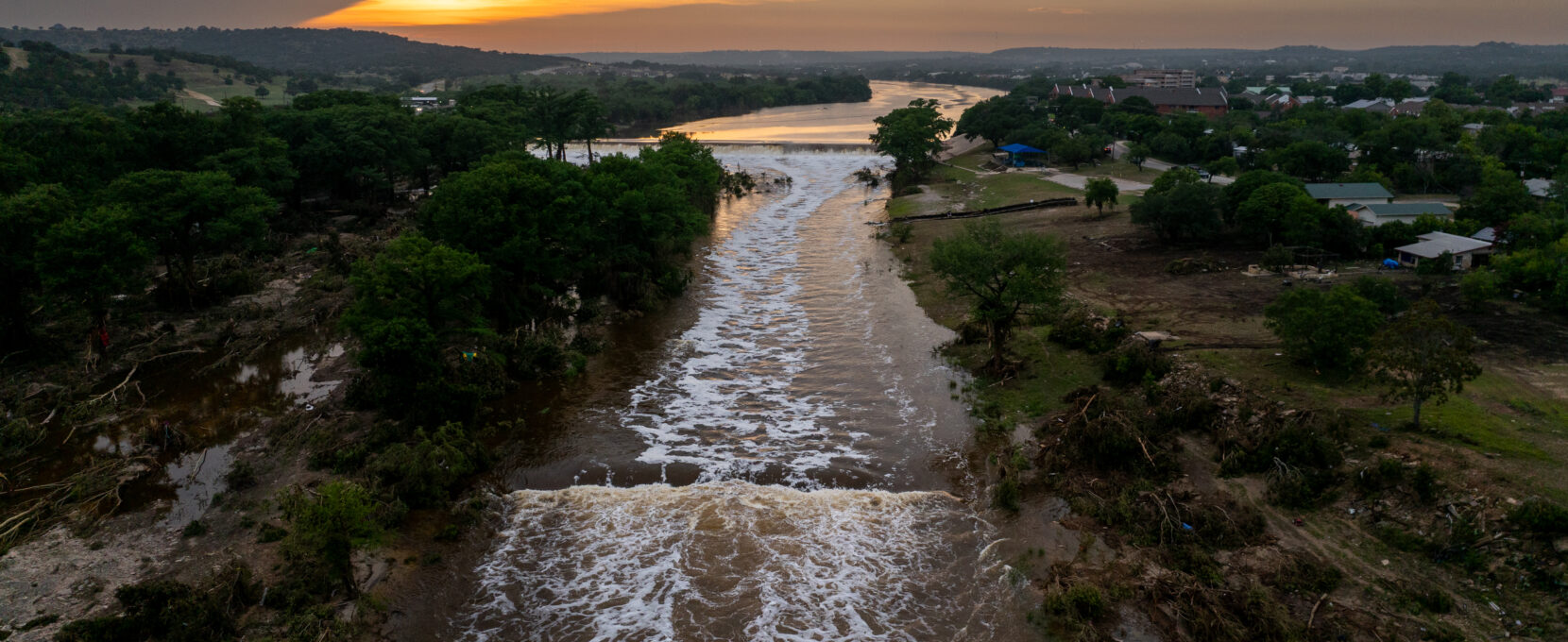 In an aerial view, the sun sets over the Guadalupe River on July 06, 2025 in Kerrville, Texas. Heavy rainfall caused severe flooding along the Guadalupe River in central Texas, leaving more than 80 people reported dead.