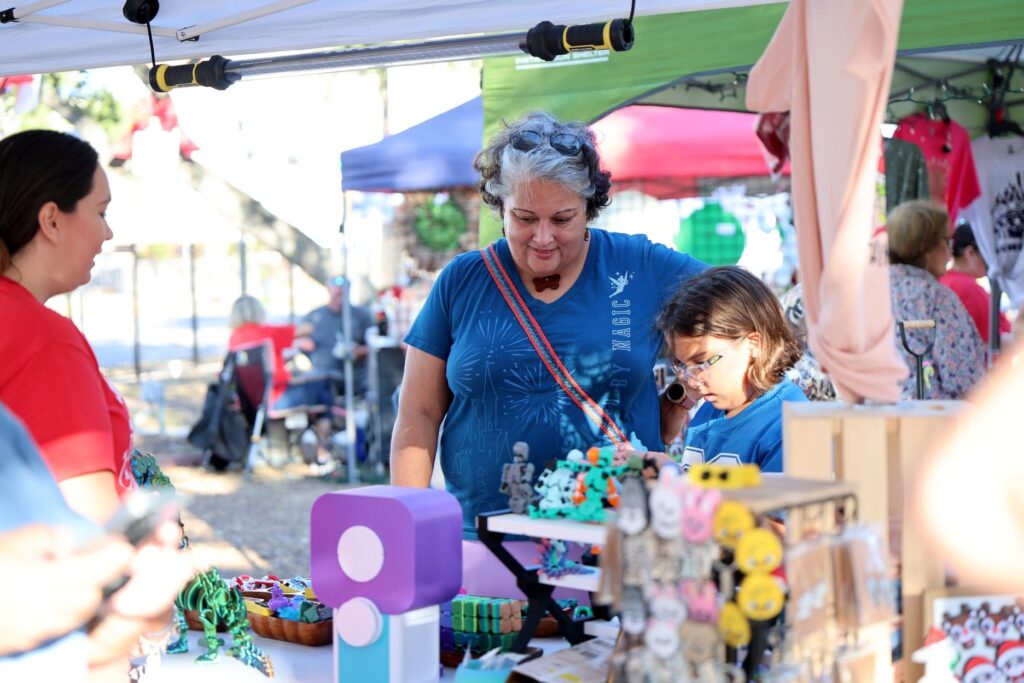 A woman and child looking at a vendor table in downtown Corpus Christi, Texas.