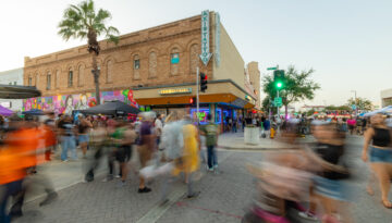 A crowd of people walk through the streets of Downtown Corpus Christi during the monthly First Friday ArtWalk.