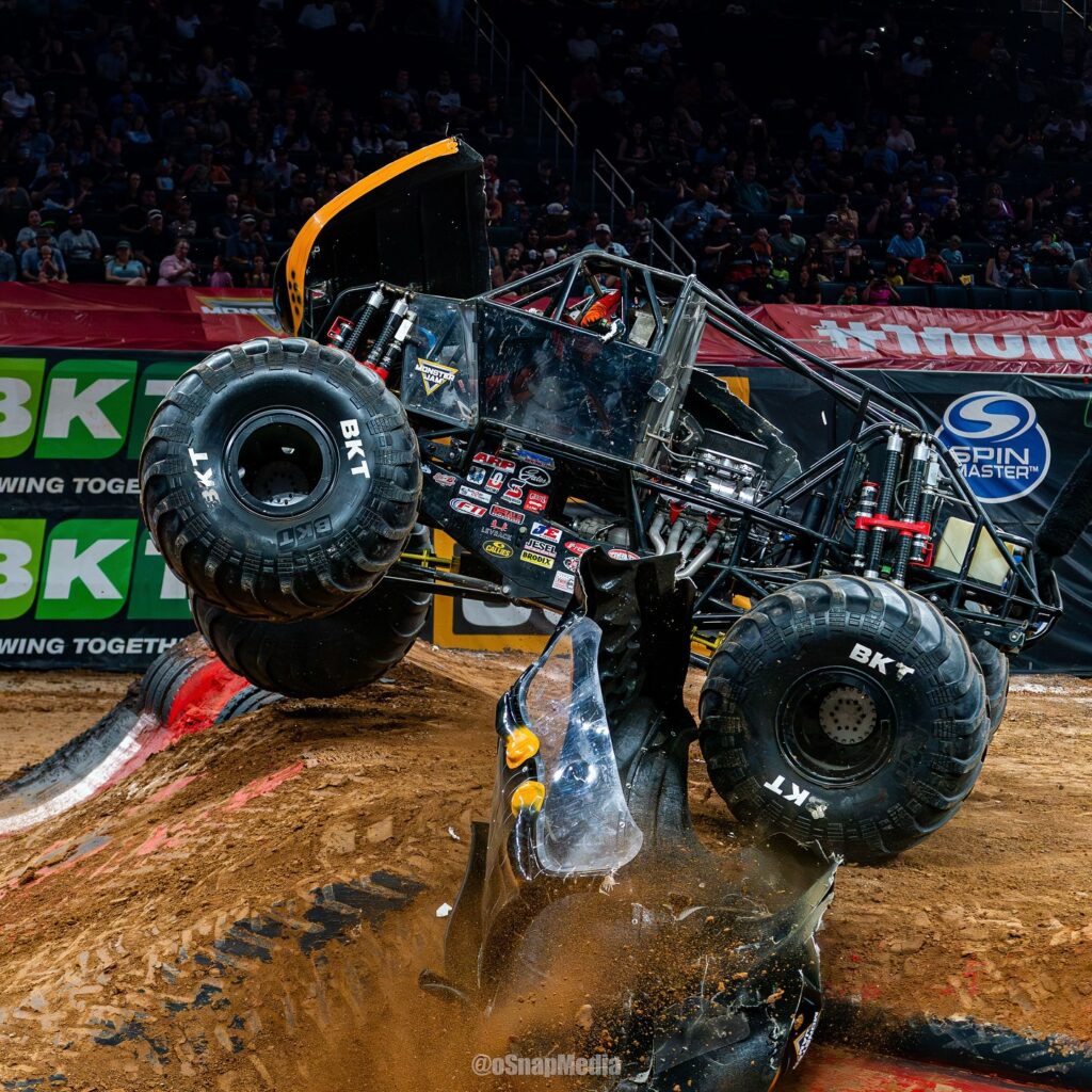 Berto Treviño's Monster Jam truck Monster Mutt Rottweiler jumps over two dirt ramps.